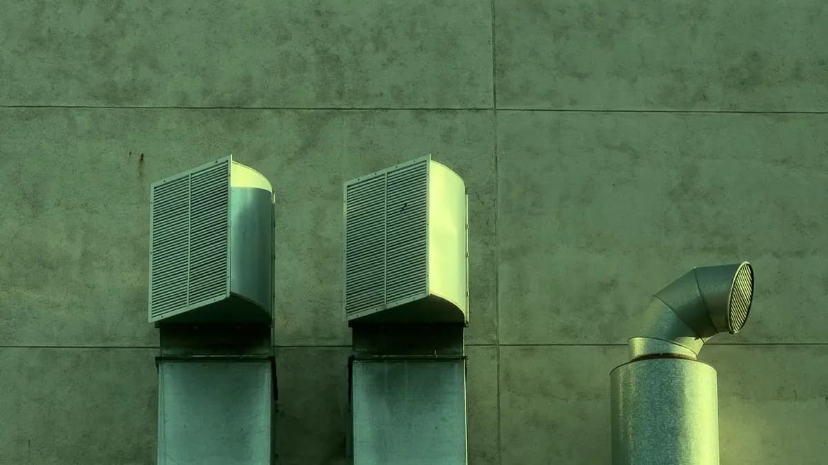Industrial HVAC ventilation ductwork installed on an exterior wall