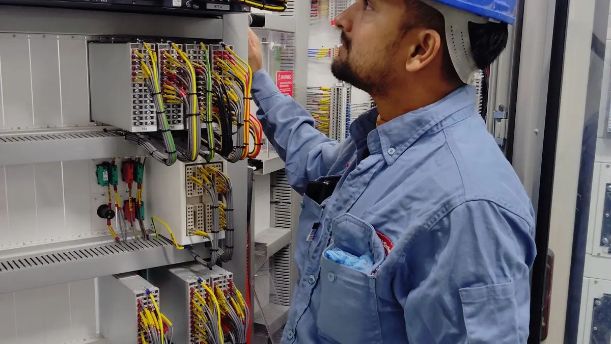 Technician working inside an industrial electrical control enclosure