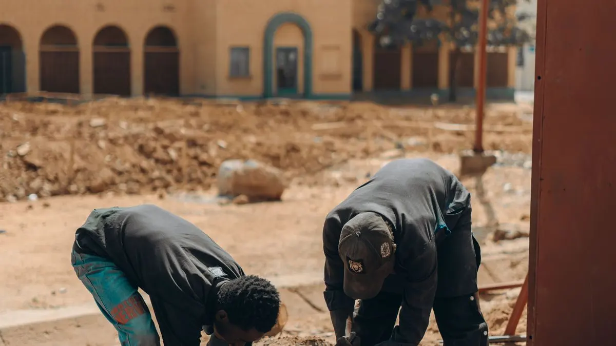 Workers assembling metal components at an outdoor job site