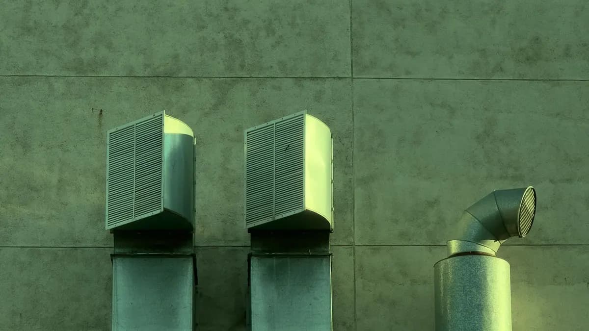 Installed rectangular metal air ducts on a modern building exterior